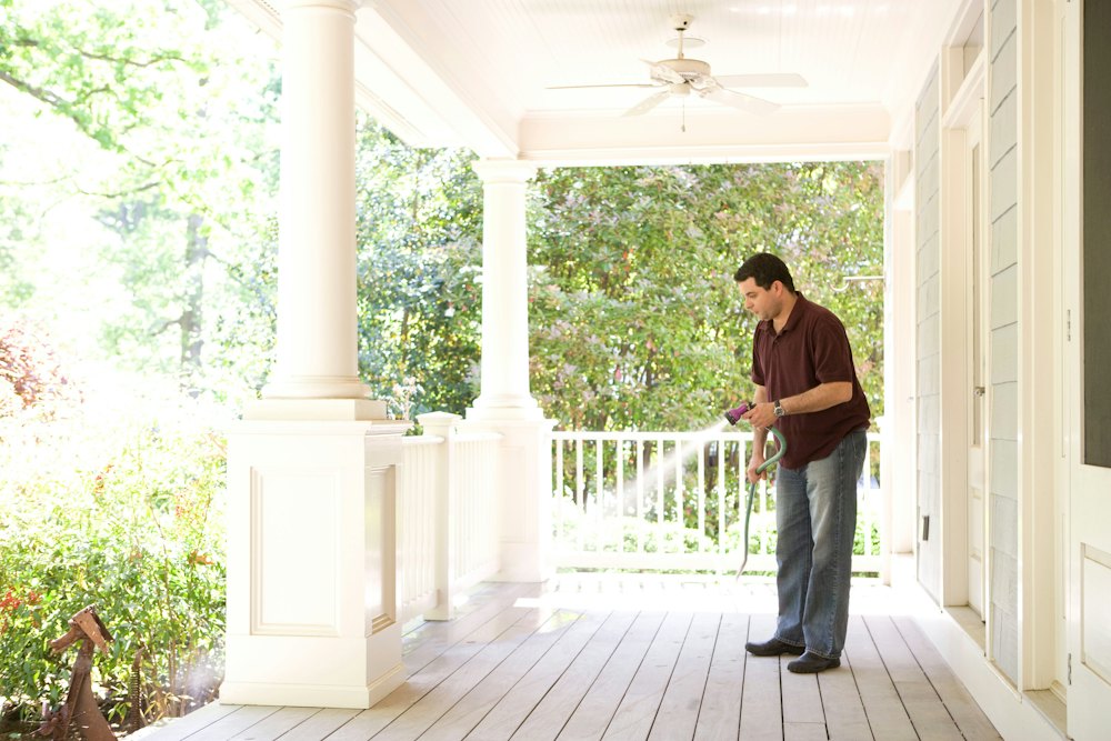 Technician spraying around the porch of a house